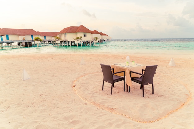 stół obiadowy i krzesło na plaży z widokiem na morze w Malediwy