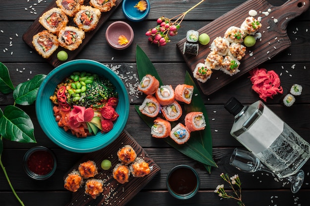 Stół podawany z sushi, bułkami i tradycyjnym japońskim jedzeniem na ciemnym tle. Widok z góry.