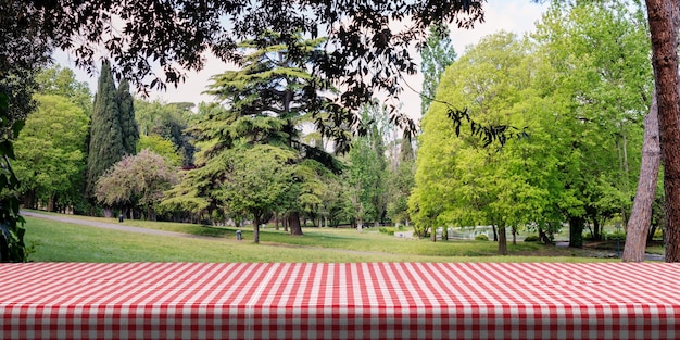 Stół pokryty czerwonym obrusem na tle zielonego parku kopii przestrzeni ilustracji 3d