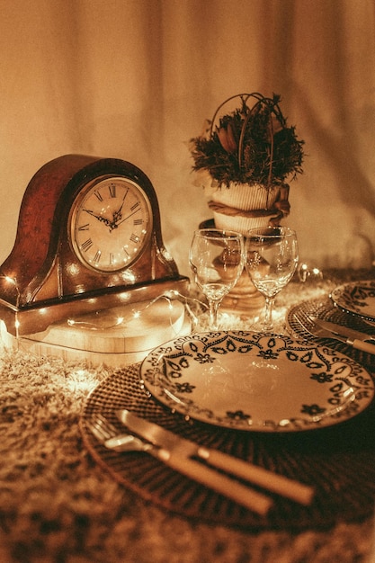 Zdjęcie stół ustawiony na kolację z zegarem i talerzem z świecą w nim