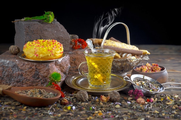 Zdjęcie stół z filiżanką herbaty i czajnikiem z żółtym płynem.