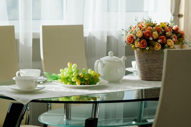 Zdjęcie stół z zastawą stołową do herbaty, winogron, kwiatów