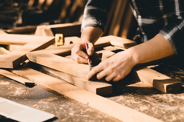 Stolarze z dużym doświadczeniem w produkcji mebli. master of woodcraft męskiej pracy z drewnianym kawałkiem rękodzieła z drobnymi szczegółami.