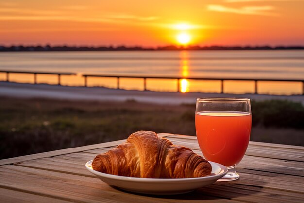 Stolik śniadaniowy na zewnątrz z croissantem i widokiem na wschód słońca