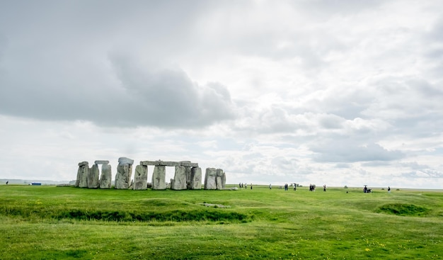 Stonehenge z nierozpoznanym turystą w pobliżu Salisbury w Anglii pod zachmurzonym niebem