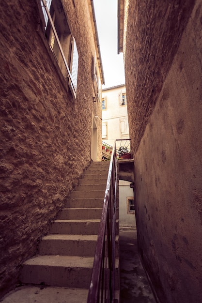 Stonowane zdjęcie dużych schodów na starej wąskiej uliczce?