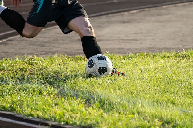 Stopa kopiąca piłkę nożną na zielonej trawie kopnięcie rogu piłki w piłce nożnej