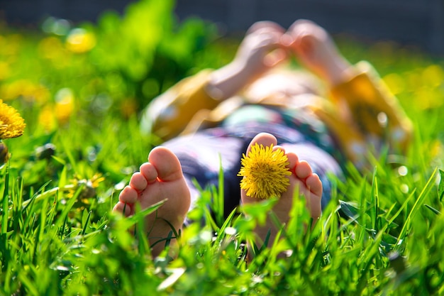 Stopy Dzieci Na Trawie W Ogrodzie Dandelions Wiosną Selektywne Fokus