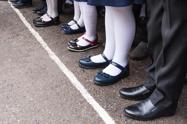 Stopy dzieci stoją w rzędzie na szkolnej linii