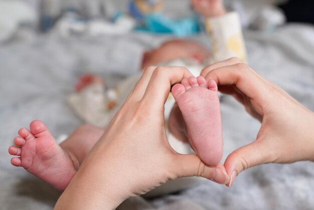 Stopy dziecka noworodka w rękach matki w koncepcji rodziny przytul dziecko nogi ciało w domu