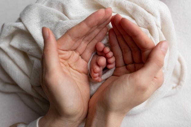 Stopy dziecka w rękach matki Nogi malutkiego noworodka w zbliżeniu broni Rodzina i dziecko Happy fa