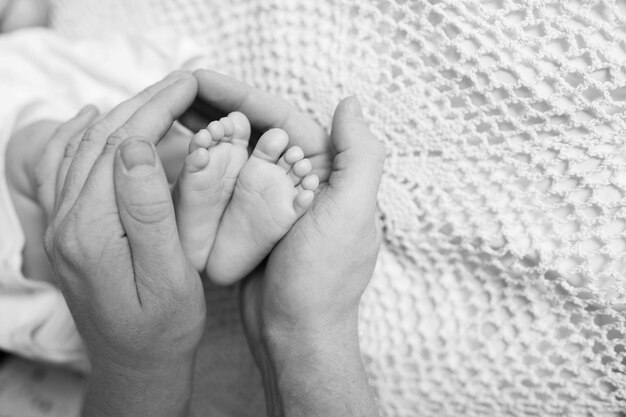 Stopy dziecka w rękach ojca Małe stopy noworodka na męskie dłonie w kształcie zbliżenie Tata i jego dziecko Koncepcja szczęśliwej rodziny