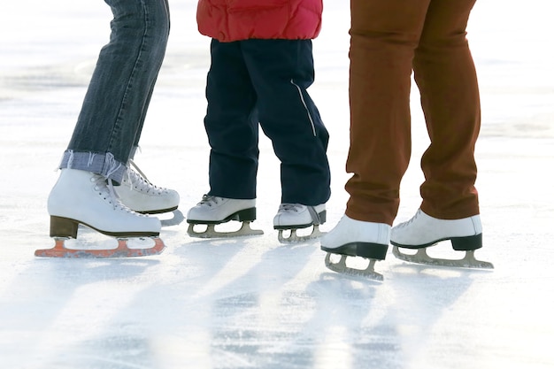 Stopy ludzi jeżdżących na łyżwach na lodowisku. Hobby i rekreacja. Sport i wakacje
