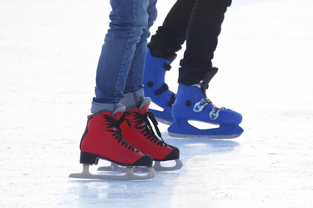 Stopy różnych osób jeżdżących na łyżwach po lodowisku