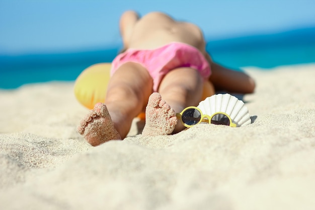 Stopy szczęśliwego dziecka w pobliżu brzegu morza w weekendowej podróży natury