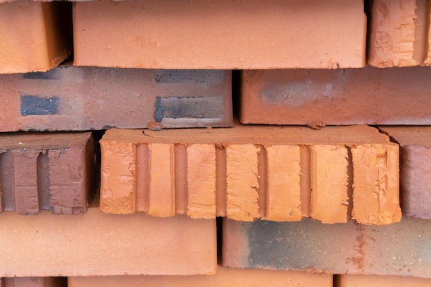 Zdjęcie stos czerwonych cegieł izolowane cegły budowlane cegły z czerwonej gliny układane są na drewnianych paletach produkcja cegieł z gliny