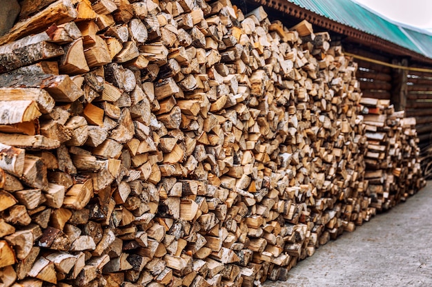 Zdjęcie stos drewna z starannie ułożonym drewnem opałowym na dziedzińcu.