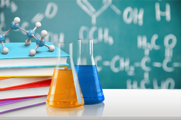 Stos książek, kolby z odczynnikami, test i eksperyment sprzętu chemicznego, edukacja chemiczna