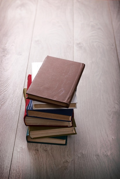 Stos książek na drewnianym tle