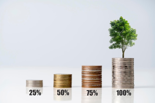 Stos monet pieniędzy rośnie wykres i drzewo, które rośnie na stosie pieniędzy Pomysł na finanse biznesu i oszczędzanie pieniędzy, inwestycje i rosnące drzewo na monetach