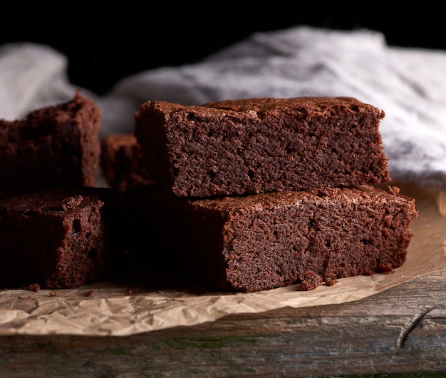 Stos Pieczone Kwadratowe Kawałki Ciasta Czekoladowe Brownie Na Brązowy Pergamin