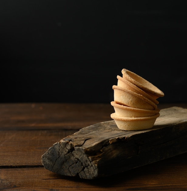 Stos pieczonych okrągłych tartlets puste na desce