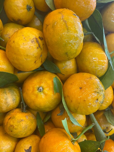 Zdjęcie stos pomarańczy z zielonymi liśćmi na nich