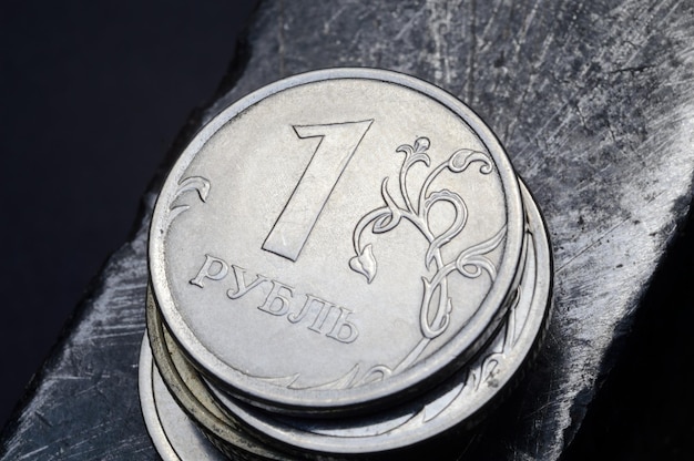 Stos rosyjskich rubli leży na podrapanej metalowej powierzchni tłumaczenie tekstu na monecie quot1 rublequot