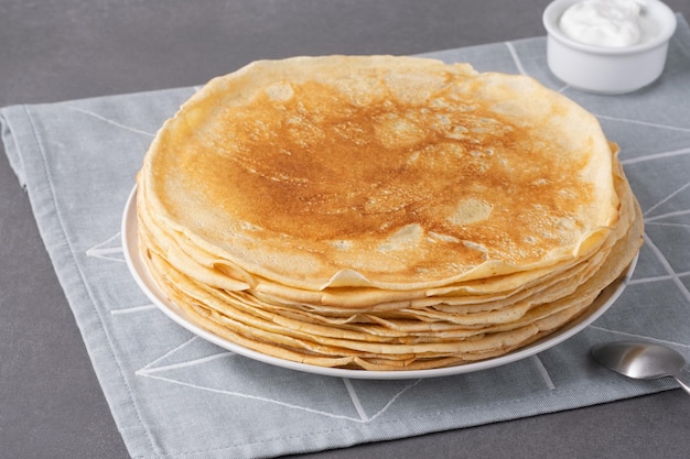 Stos tradycyjnych rosyjskich naleśników blini na szarym tle domowe rosyjskie cienkie naleśniki blini
