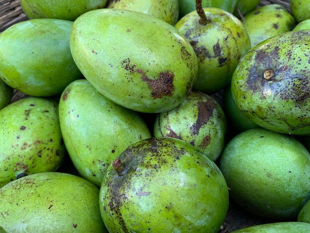 Stos zielonych mango ze słowem mango na boku