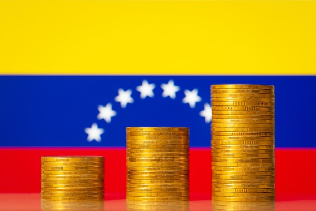 Stosy złotych monet z flagą Wenezueli w tle