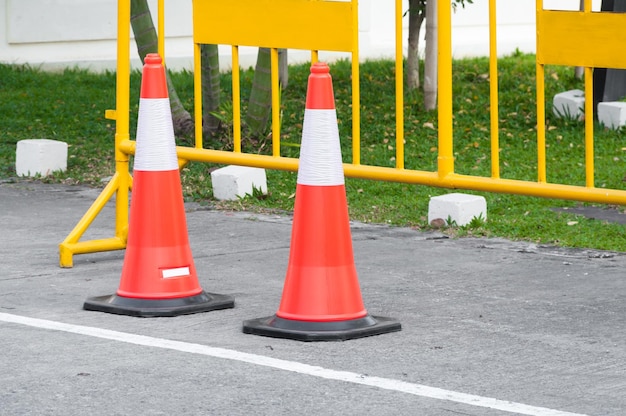 Stożek ostrzegawczy o ruchu w rzędzie do oddzielenia trasy na parkingu Widok bariery bezpieczeństwa pojazdu