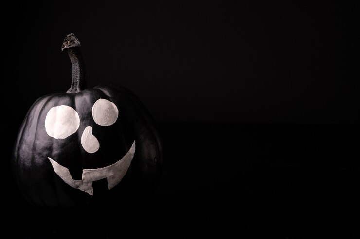 Zdjęcie straszna dynia halloween na czarnym tle. straszne twarze cukierek albo psikus