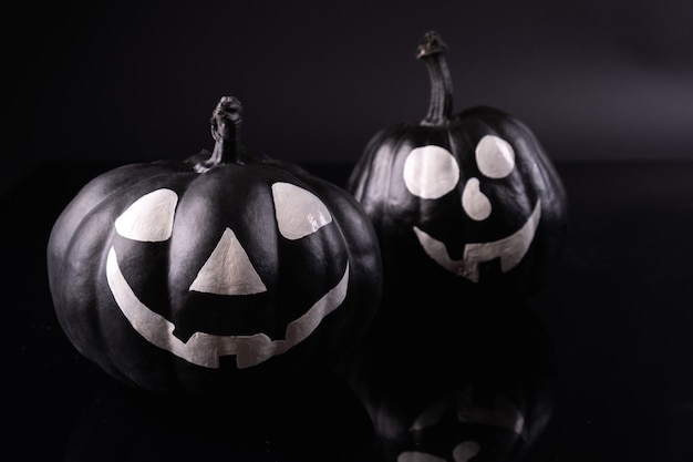 Straszne dynie Halloween na czarnym tle. Straszne twarze cukierek albo psikus