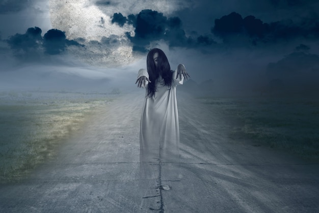 Straszny duch kobiety stojącej z tłem sceny nocnej. Koncepcja Halloween
