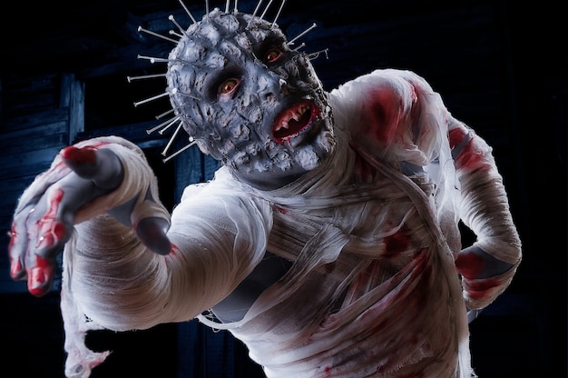 straszny zombie w stroju na imprezę halloweenową z krwią i bandażem