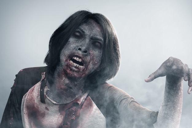 Straszny zombie z krwią i ranami na ciele spacerujący we mgle