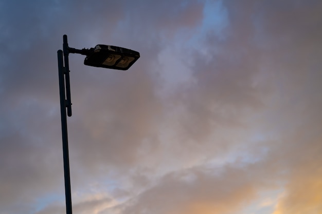 Streetlight z niebieskim i pomarańczowym chmurą i tłem nieba