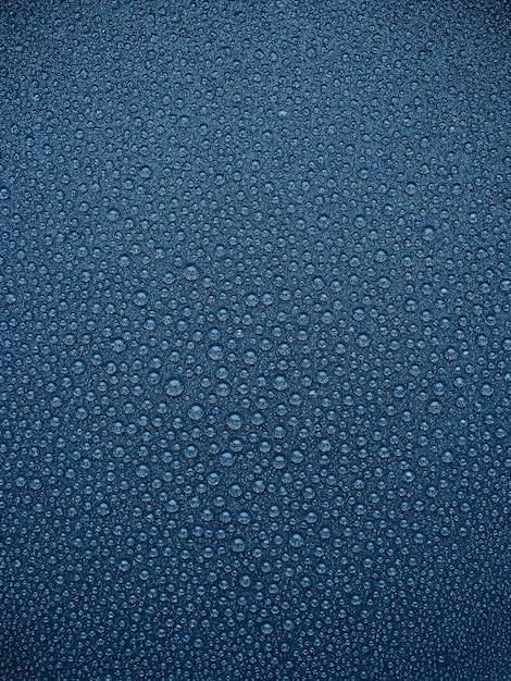 Streszczenie niebieskie tło krople wody na ciemnej powierzchni