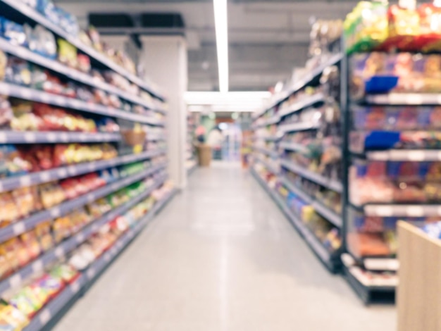 Streszczenie niewyraźne przejście supermarketu z kolorowymi półkami i nierozpoznawalnymi klientami jako tło