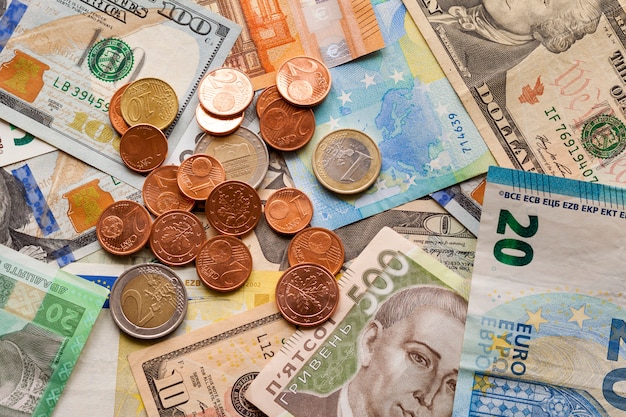 Streszczenie Wykonane Z Różnych Metalowych Monet, Banknotów Amerykańskich, Ukraińskich I Waluty Banknotów Euro. Pieniądze I Finanse, Udane Inwestycje.