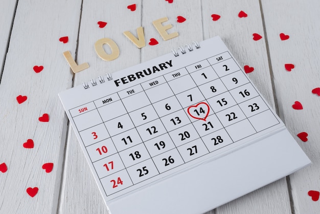 Zdjęcie strona kalendarza z czerwoną ręką napisany podkreślenie serca 14 lutego saint valentines day