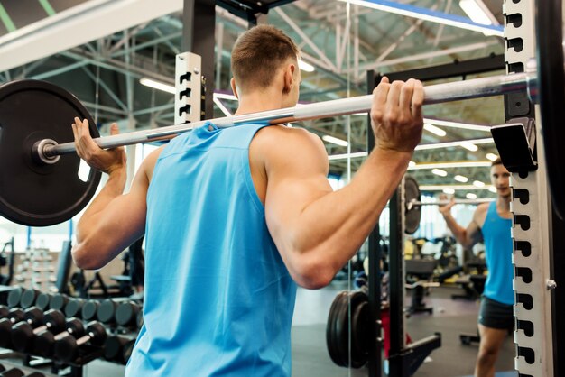 Strong Man Lifting Barbell In Gym