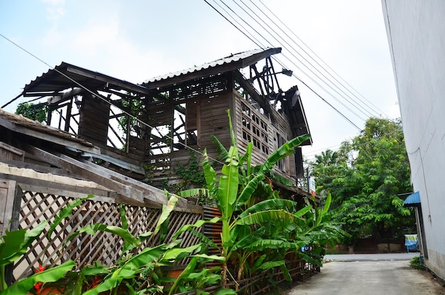 Struktura zewnętrzna zepsuta uszkodzona na zewnątrz opuszczonego drewnianego zabytkowego budynku ze starego pożaru domu z drewna w wiosce w Bangkoku w Tajlandii