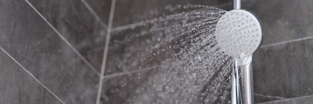Strumienie wody wypływającej z głowicy prysznicowej w zbliżeniu w łazience