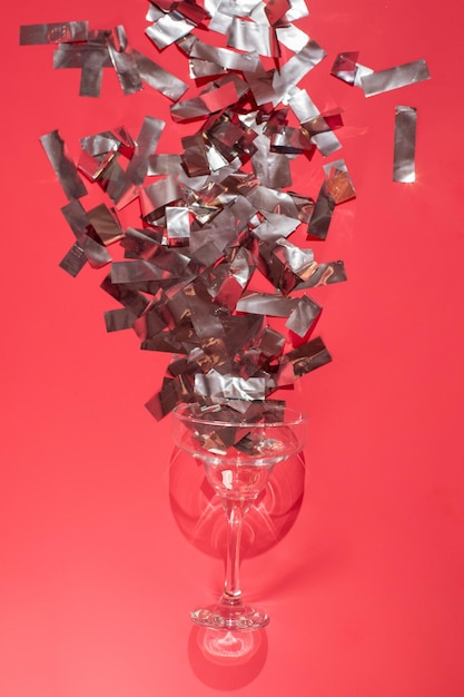 Zdjęcie strzał studio kieliszek wina na białym tle na różowym tle zbliżenie z uroczystym konfetti
