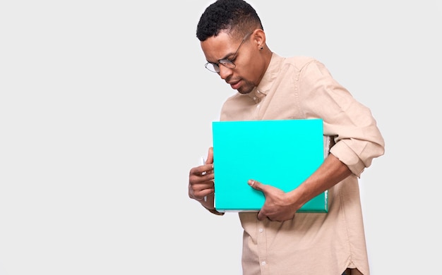 Strzał studio młodego Afroamerykańskiego biznesmena trzymającego folder z dokumentami Pewny student płci męskiej w swobodnym stroju z folderem z papierami i dokumentami na egzaminy z miejscem na kopię na reklamę