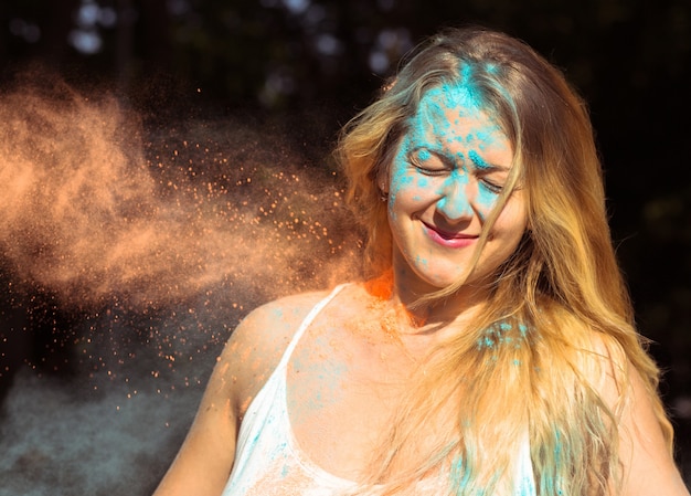 Strzał zbliżenie fajne blond kobieta z długimi kręconymi włosami z okazji festiwalu Holi