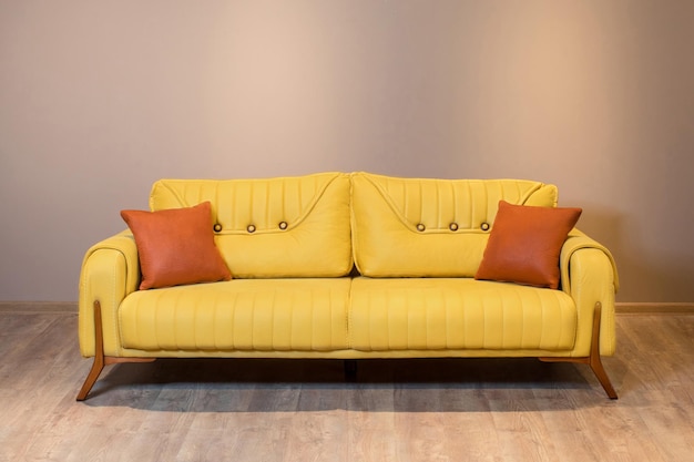 Strzał zbliżenie żółtej nowoczesnej kanapie na drewnianej podłodze