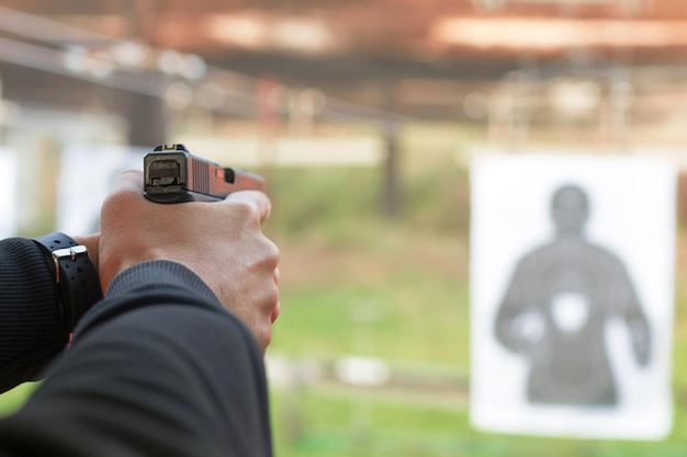 Zdjęcie strzelanie z pistoletu. człowiek mający pistolet w strzelnicy.